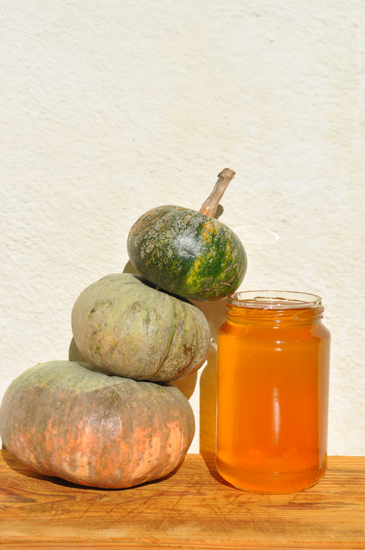 Tarro de miel con calabazas en un bodegón otoñal